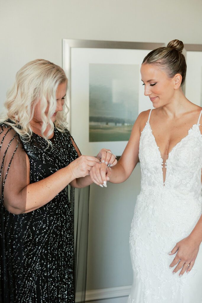 mom helping bride with bracelet